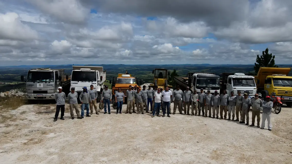 Equipe da Pedras Carula reunida com os caminhões na pedreira